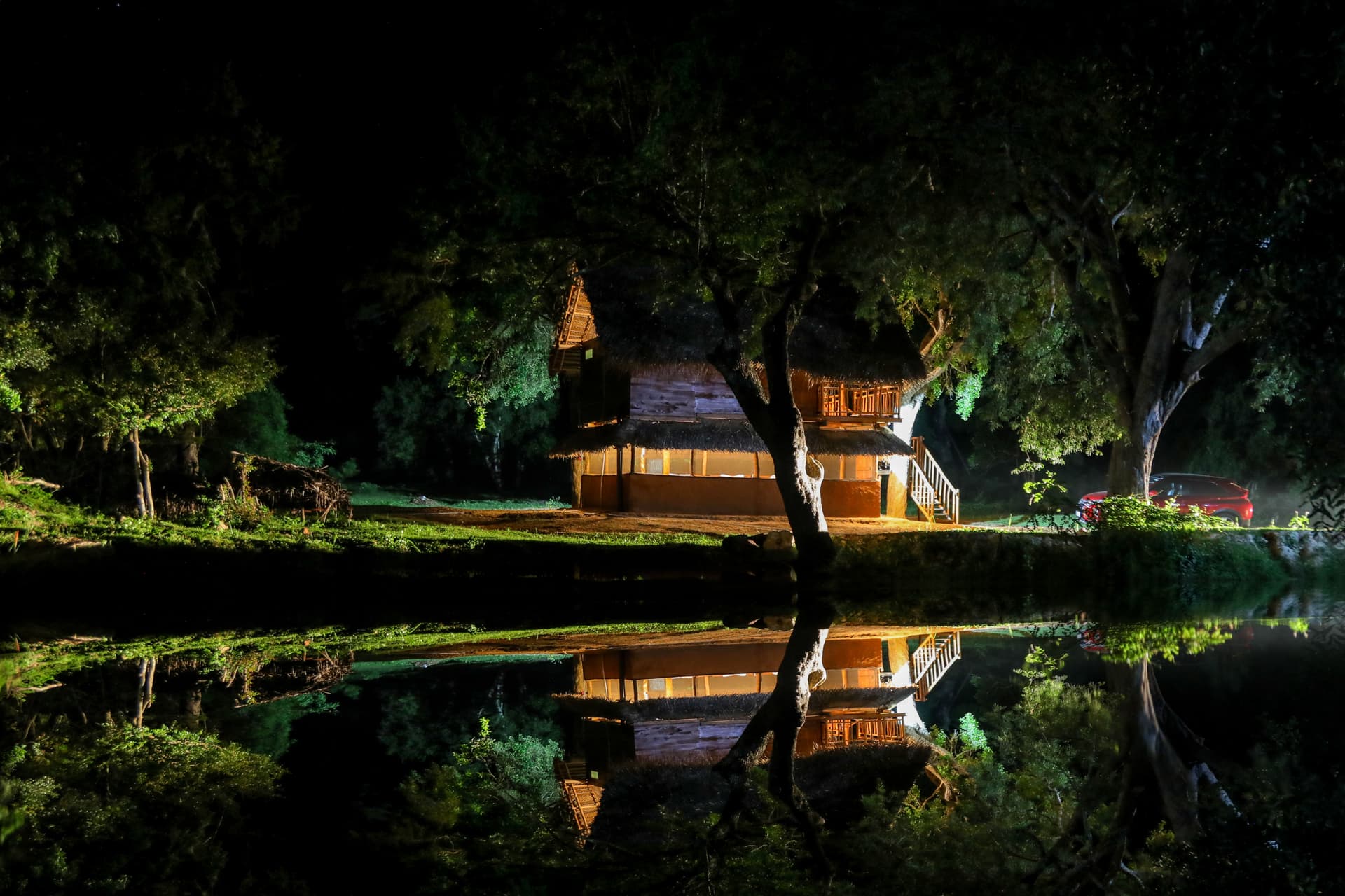 A double bed dressed with a traditional patterned throw and a mosquito net — rustic luxury in the heart of Yala.